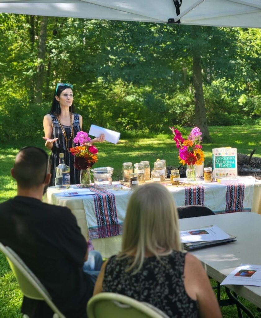 A woman standing at the table with flowers.