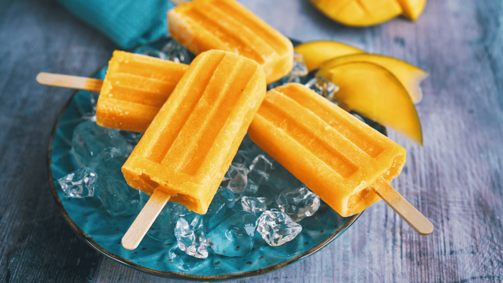 A plate of popsicles with bananas on top.