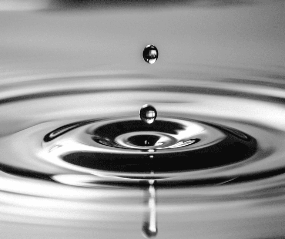 A water drop falling into the water with one droplet falling.