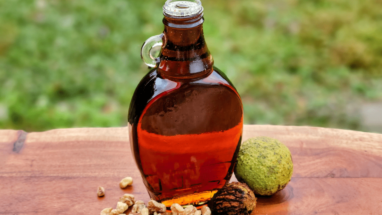 A bottle of syrup and nuts on the table.