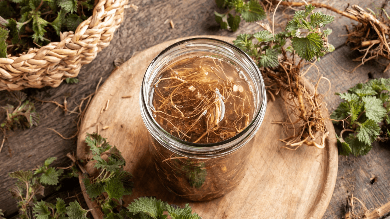 A jar of dried herbs on top of a wooden board.