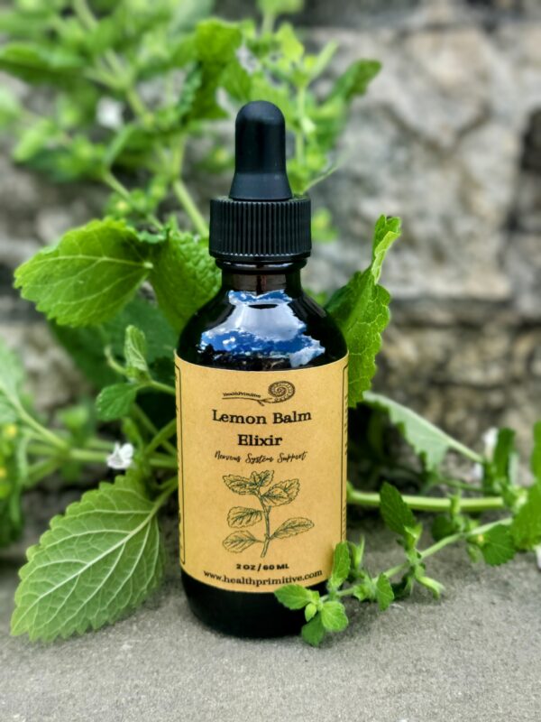 A bottle of lemon balm tincture sitting on top of a plant.
