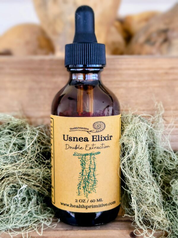 A bottle of usea elixir sitting on some green plants