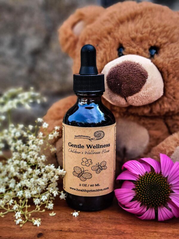 A teddy bear sitting next to a bottle of essential oils.