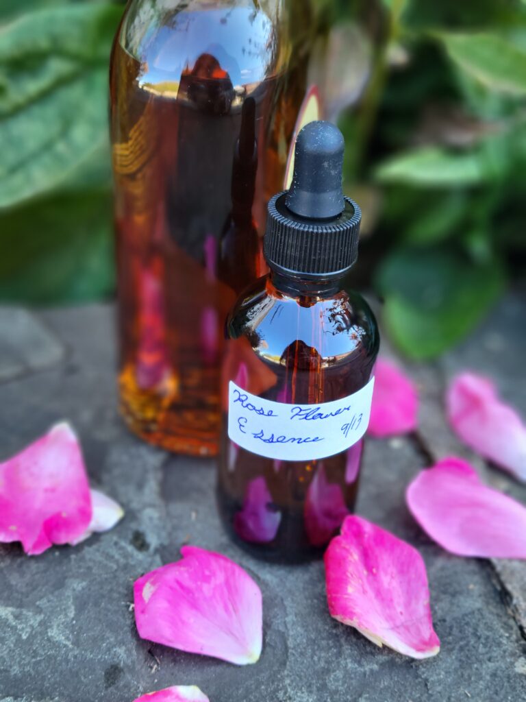 A bottle of oil and some pink flowers