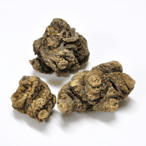 Three pieces of black truffle are sitting on a white surface.
