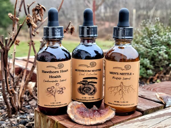 Three bottles of herbal tinctures sitting on a wooden table.